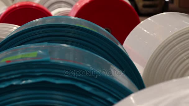Shot van de rollen van plastic zeilen in diverse kleuren — Stockvideo