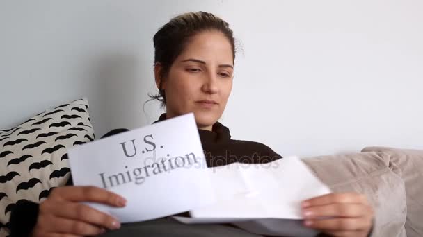 Lövés a nő ül a kanapén olvasó Usa bevándorlási dokumentumok — Stock videók