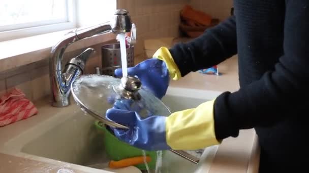 Shot of Young woman washing dishes in sink — Stock Video