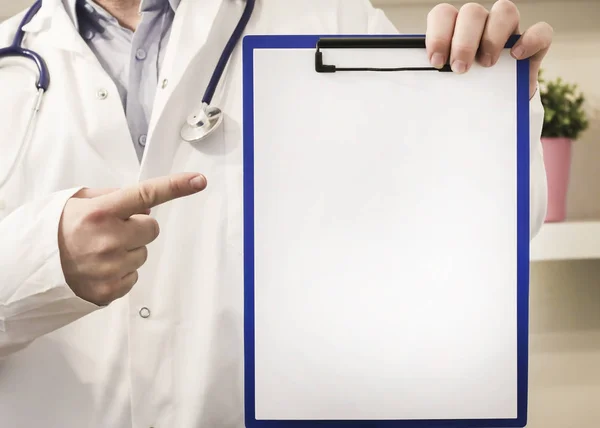 Doktor směřující do schránky s prázdný papír — Stock fotografie