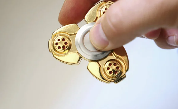 Golden fidget spinner toy on dark aurface — Stock Photo, Image