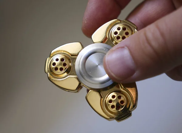 Mano celebración fidget spinner juguete dorado — Foto de Stock