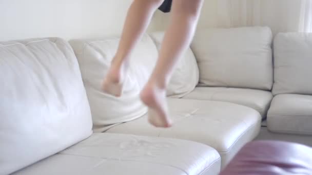 Anak muda melompat di sofa — Stok Video