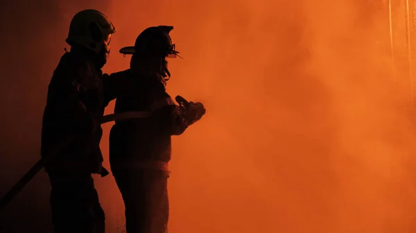 アジアの消防士の背面ビューは 防火スーツを着用してください 消火スプレー水の戦い 緊急事態だ火災 近くで — ストック写真