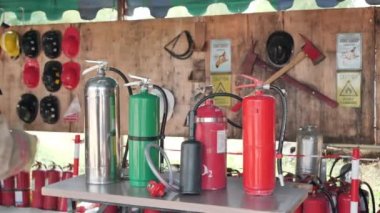 Asyalı itfaiyeci görev yapmak için yangın söndürücüyü tutuyor. Yangın tatbikatı konsepti. Yavaş Hareket