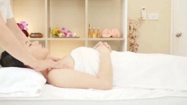 Genç Asyalı kadın güzellik salonunda masaj yaptırıyor. Vücut masajı, rahatlatıcı masaj, kaplıca ve vücut bakımı. Dolly kaydırıcı