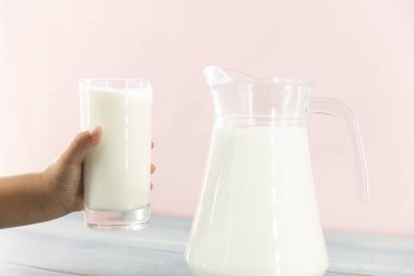 Bir bardak sütle çocuk eli. Sağlıklı yaşam için süt iç.