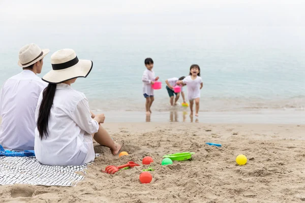 Pai Mãe Sentam Praia Olhando Para Crianças Brincando Brinquedos Areia — Fotografia de Stock