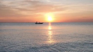 Akşam günbatımında arka plan denizi, gökyüzü ve balıkçı teknesi. Yavaş çekim