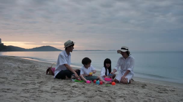 快乐的亚洲家庭四个人在暑假里一起在沙滩上玩玩具在早晨 日出时分 假日和旅行概念 — 图库视频影像