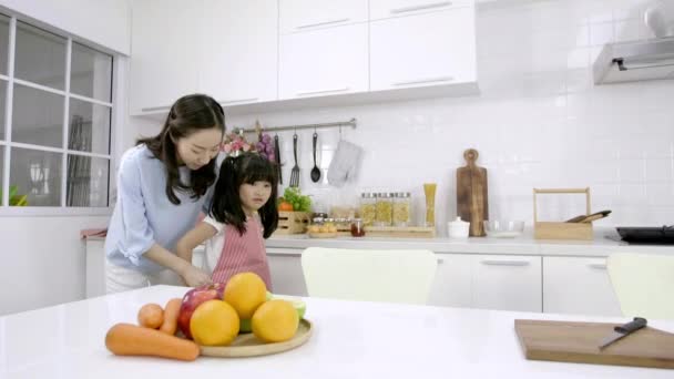 幸せなアジアの家族母は自宅のキッチンで娘のエプロンを着ています 朝食の準備 — ストック動画