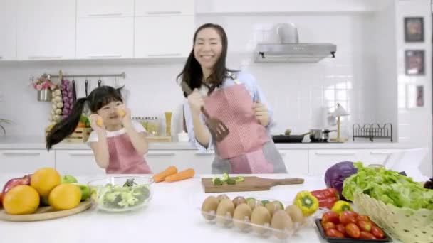 幸せなアジアの家族一緒に好きな歌にダンスを移動自宅のキッチンルームで陽気な母親と小さな娘 余暇とライフスタイルのコンセプト — ストック動画