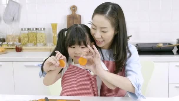 幸せなアジアの家族母親と子供の娘は自宅のキッチンで一緒に遊んでいます — ストック動画