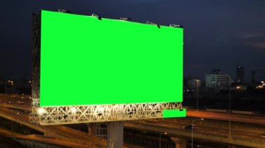Alacakaranlıkta Bangkok, Tayland 'da şehir arkaplanı olan çevre yolunda yeşil reklam panosu..