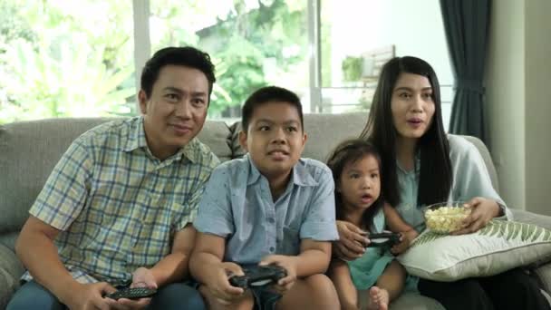 アジア系家庭家庭家庭家庭のリビングルームでビデオゲームをする母と父と2人の子供 家族の幸せの瞬間 — ストック動画