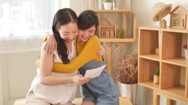 Щаслива Азіатська Сім Мама Донькою Підлітком Обіймається Читає Картку Кімнаті — стокове відео