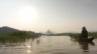 Ağaç kürek çeken balıkçılar gölde balık tutmaya hazırlanıyor. Akşam, gün batımında. Kavramsal Balıkçı yaşam tarzı. Lopburi, Tayland. 