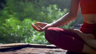 Şelalede yoga yapan ya da pratik yapan Asyalı kadını kapatın, meditasyon seansında Lotus pozu verin. Güzel manzara, doğal arka plan, Tayland.