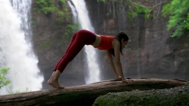 亚洲女人在瀑布边练习或做瑜伽 美丽的风景 自然背景 女性职业瑜伽 — 图库视频影像