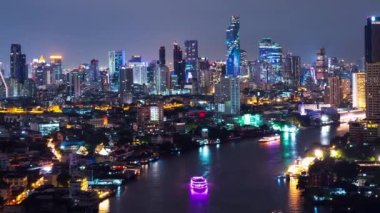 Geceleyin Bangkok 'un hızlandırılmış görüntüsü ve Chao Phraya Nehri' nde bir tekne gezisi. Yüksek açılı şehir arka planı ve Tayland 'ın başkenti Asya' da Açık Renk