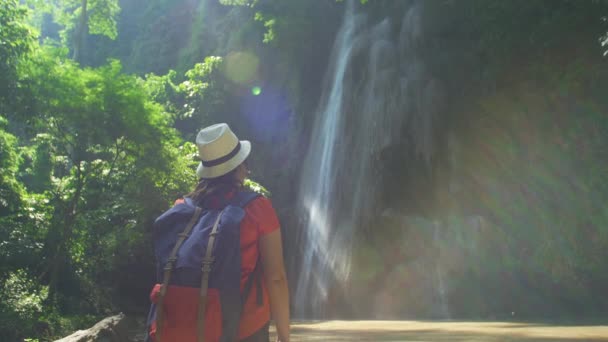 Задньому Плані Азіатська Жінка Рюкзаком Розслаблює Руки Дивлячись Водоспад Подорожі — стокове відео