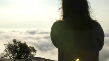 Kadın fotoğrafçının arka görüntüsü, sabah DSR kamerasıyla fotoğraf çekiyor ve güneş doğarken dağın zirvesinde sis, deniz sisi arka planında. Turizm, Seyahat, Profesyonel Fotoğrafçı