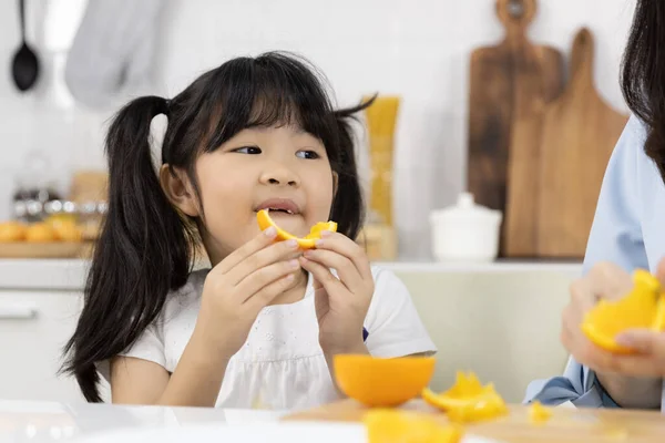 Happy Asian Family Close Little Girl Eating Orange Fruit Mother — Stock Photo, Image