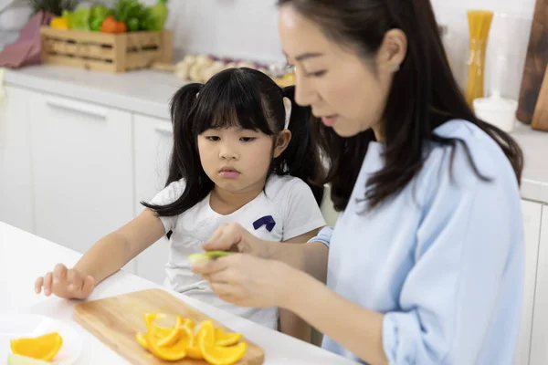 Happy Asian Family Little Girl Eating Orange Fruit Mother Preparing — Stock Photo, Image