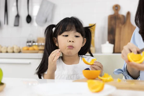 Gelukkig Aziatisch Gezin Close Van Klein Meisje Dat Sinaasappelfruit Eet Rechtenvrije Stockafbeeldingen