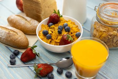 Sağlıklı kahvaltı. ekmek, portakal suyu, çilek, yabanmersini, süt ve tahıl gevreği ahşap masada. Sağlıklı yemek.