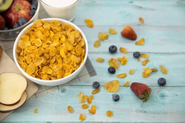 Sağlıklı kahvaltı. ekmek, meyve, çilek, yabanmersini, kivi, bardakta süt ve hasırda mısır gevreği ve ahşap masa. Arka plan Sağlıklı yiyecekler.