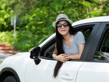 Mutlu Asyalı kadınlar yaz tatili seyahatlerine gülümsüyor. Güneş ışığı, güneş ışığı ve ağaç doğal arka planıyla yollarda. Turist tatili kavramı