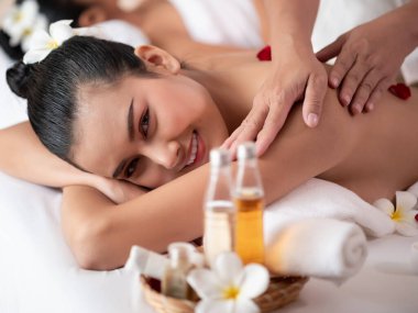 Güzel, genç Asyalı bir kadın Spa 'daki yatak döşeğinde uzanıyor ve gülümsüyor. Sağlık için Tayland masajı. Kadınlara odaklan