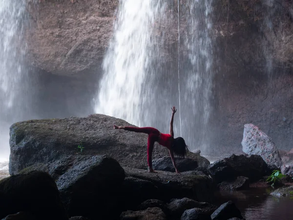 アジアの女性は滝でヨガを練習したりしています 美しい風景 自然背景 ロイヤリティフリーのストック画像