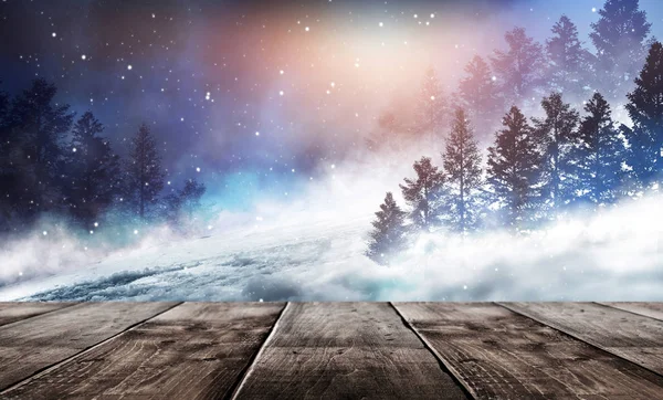 冬の背景 目の前に木製のテーブルと冬の雪の風景 夜の暗い冬の森の背景 雪霧月明かり月明かりの森の中の暗いネオンの夜の背景 — ストック写真
