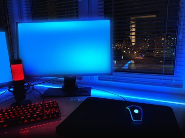 Neon ışıkları olan bir oda. Oyun Alanı. Bilgisayar oyunları, oyun sporları ve akış için iç mekan. İç kısımda soyut neon arkaplan. Odanın gece görüşü, beyaz masa, neon ışık. Mavi ve pembe neon.