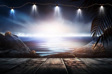 İskelede bir gece feneri, gün batımlı bir deniz manzarasının arka planına karşı. Palmiye dalları, siluetler, güneş ışığı. Tahta masa. Gece görüşü, açık deniz manzarası.