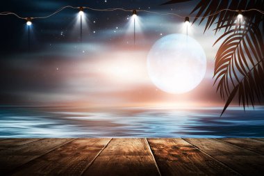 İskelede bir gece feneri, gün batımlı bir deniz manzarasının arka planına karşı. Palmiye dalları, siluetler, güneş ışığı. Tahta masa. Gece görüşü, açık deniz manzarası.