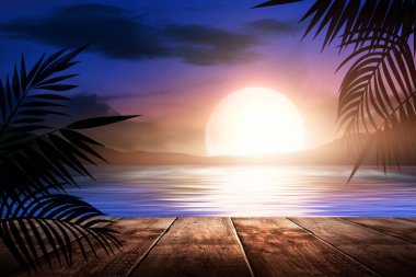 Gün batımlı deniz manzarası. Palmiye dalları, siluetler, güneş ışığı. Deniz kenarındaki tahta masa. Gece görüşü, açık deniz manzarası.