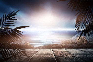 Gün batımlı deniz manzarası. Palmiye dalları, siluetler, güneş ışığı. Deniz kenarındaki tahta masa. Gece görüşü, açık deniz manzarası.
