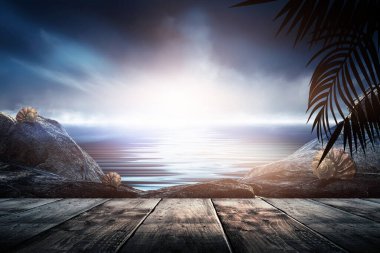 Gün batımlı deniz manzarası. Palmiye dalları, siluetler, güneş ışığı. Deniz kenarındaki tahta masa. Gece görüşü, açık deniz manzarası.