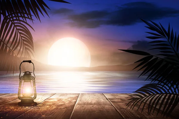 码头上的夜灯 映衬着大海晚霞的背景 棕榈树分枝 木制桌子 露天海景 — 图库照片
