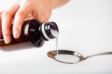 el ile metal kaşık sıvı ilaç dökün