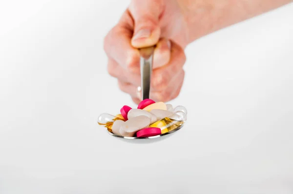 Montón de pastillas en cuchara sobre fondo blanco — Foto de Stock