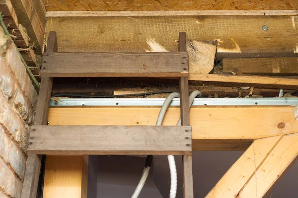 Escalera de madera colocada en el agujero del ático para ser renovado — Foto de Stock