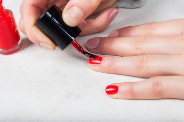 Tırnak, kendini m kırmızı cilalamak için aplikatör fırça kullanarak