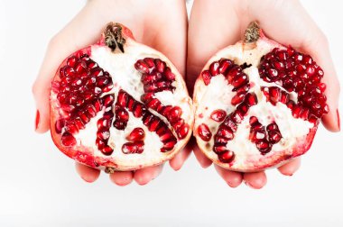 İki halfs kesilmiş nar taneleri ile elinde tutan