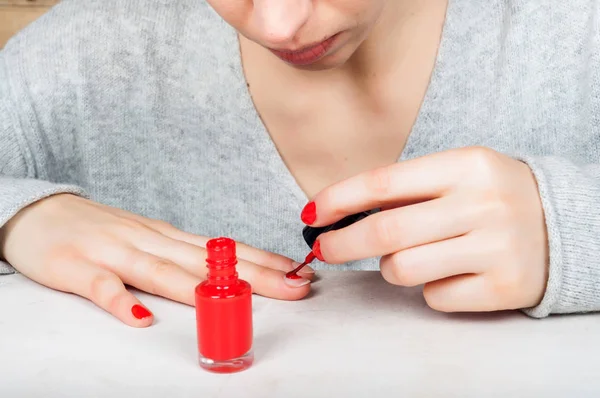 Usando cepillo aplicador para aplicar esmalte rojo a la uña, auto m — Foto de Stock