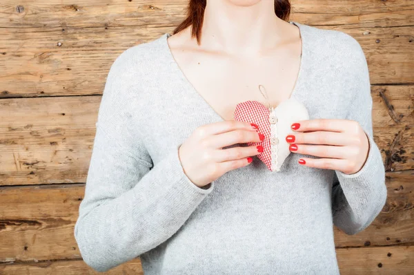 Концепция любви - девушка с текстильным красным сердцем в руках — стоковое фото