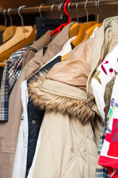 Повешение различных одежд в шкафу стойки — стоковое фото